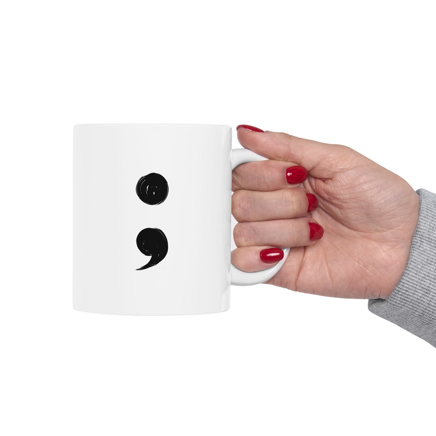 Hand holding a white mug with black punctuation marks on a white background