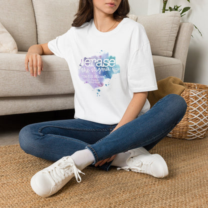 Person wearing a white t-shirt with 'Erase the Stigma' text, sitting on the floor in a living room.
