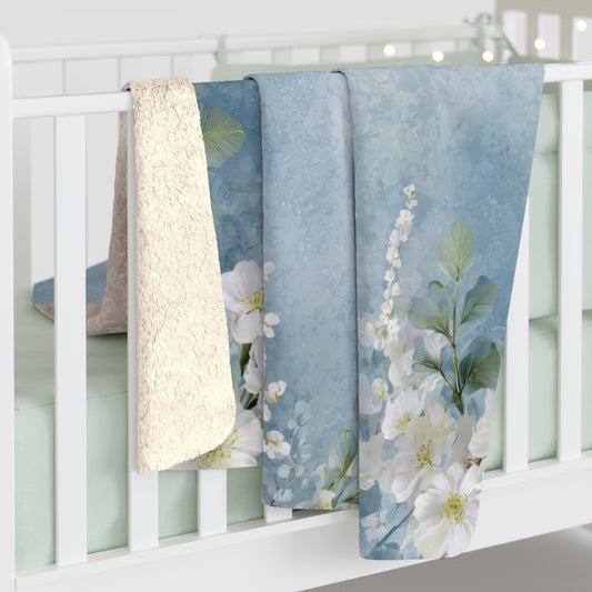 Floral-patterned baby blankets hanging on a white crib