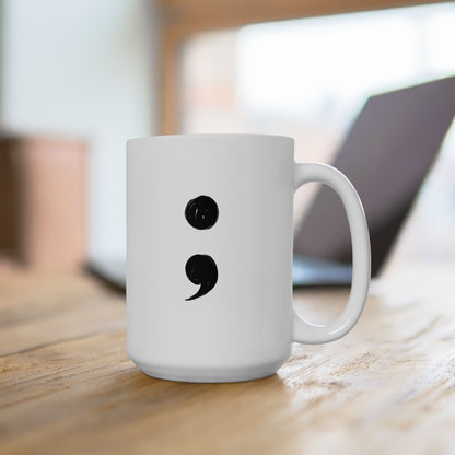 White mug with a black semicolon symbol on a wooden surface